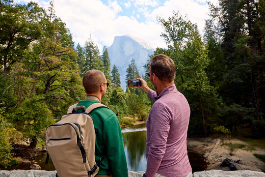 Friends capture photos of a half dome rock formation