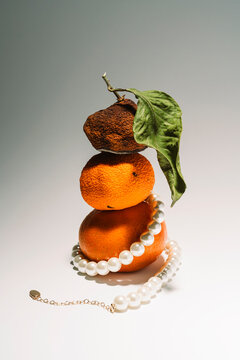 Pearl necklace wrapped around tangerine stack