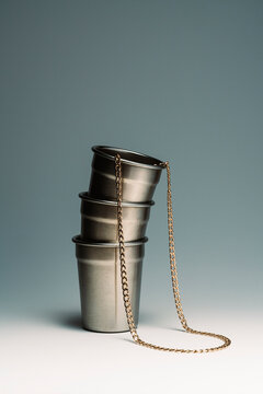 Gold chain hanging from metal cup stack