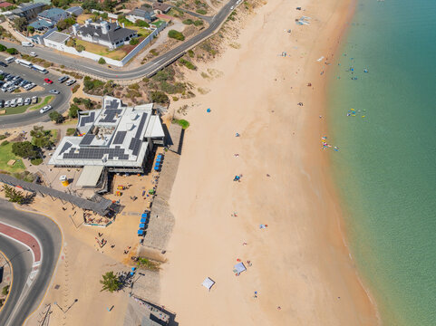 Paddle borders and beachgoers on a wide sandy beach 