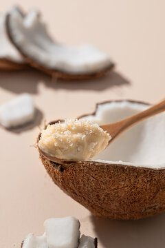 Fresh coconut with a wooden spoon scooping out the creamy flesh