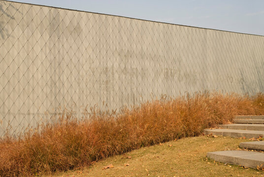 Wall with textured design and grass near steps 