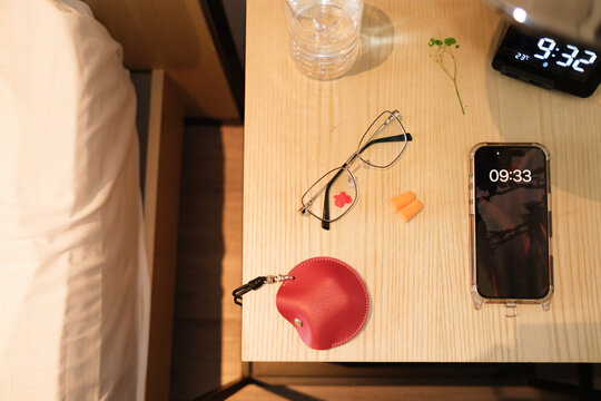 Various items on a bedside table in a hotel room