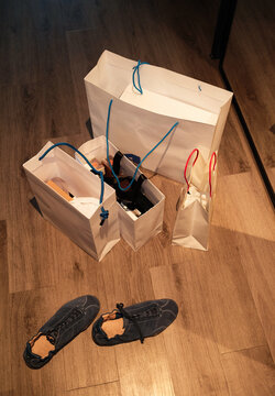 Shopping bags are placed on the floor with shoes nearby