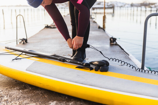 Close Up of Woman Securing Safety Leash to Full Body Wetsuit