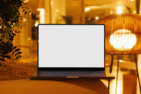 Laptop mockup with white screen in hotel lounge