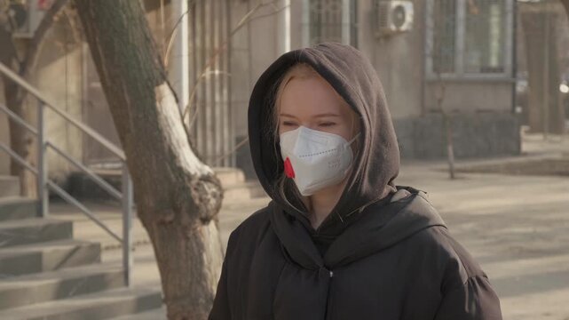 Woman Outdoors Wearing Mask, Hooded Coat, Outdors, Maintaining Distance, Health. Protection Mask for Health. Eco Volunteer, FFP3 KN99 Filter Respirator, Safety, Environmental problem, Pandemic, Virus
