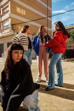 Friends chatting together in a city square on a sunny day