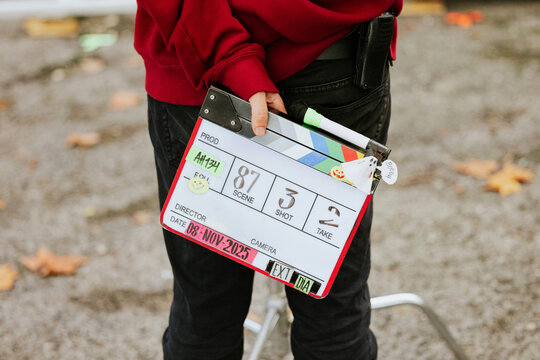 Film crew member holding a clapperboard on set