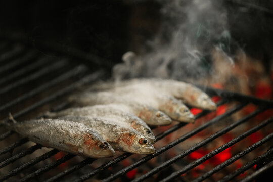 Grilled sardines on a smoky barbecue grill
