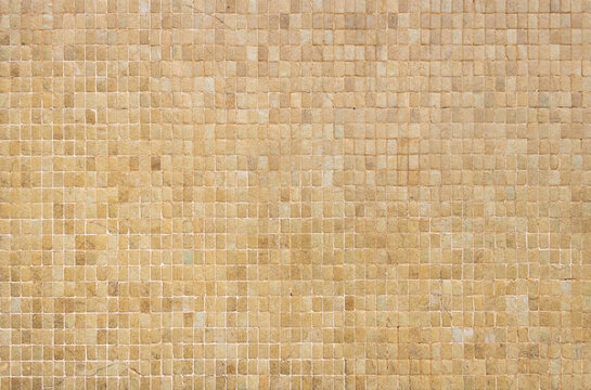 Beige stone wall with small square tiles pattern