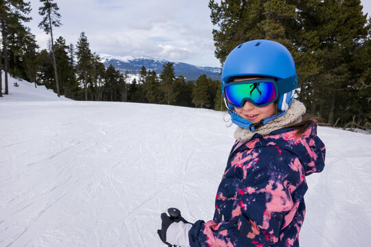 Child Smiles While Skiing on a Snowy Mountain in Winter