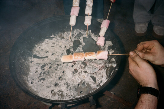 Marshmallows Roasting Over a Fire Pit During a Night Gathering