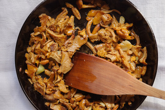 Galletti Mushrooms and garlic in a Frying Pan With a Wooden Spoon