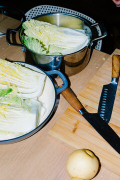 Medium shot of a pot containing raw cabbage coated with salt