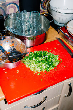 Chopped green onions on a cutting board next to various dishes