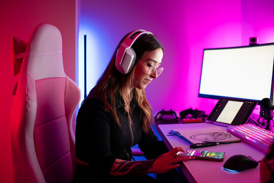 Content Creator Using Smartphone at Gaming Desk