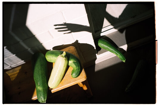 Zucchini on Wooden Stool with Dramatic Sunlight and Shadows