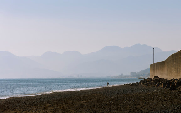 Evening Coastal Scenery: A Solitary Angler on the Vast Beach.