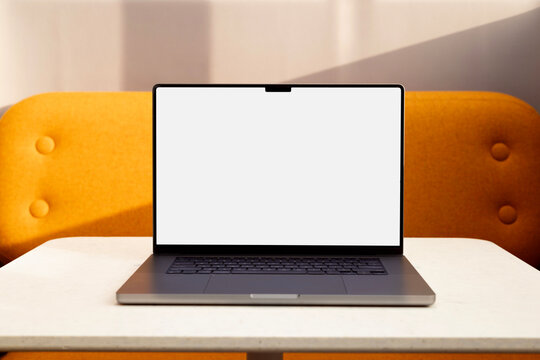 Business laptop mockup with white screen on indoor table