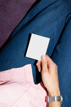 Hand holding blank card over denim jeans