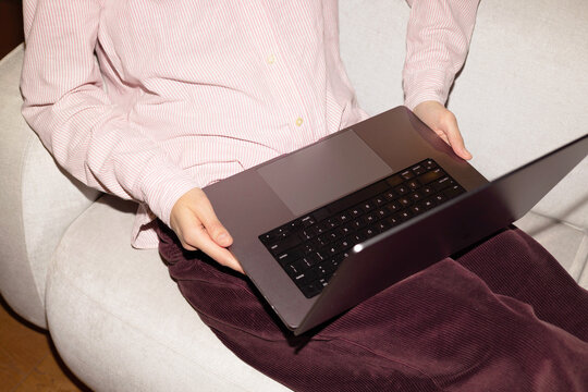 Person using laptop on lap while sitting indoors
