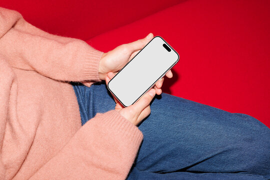 Businessperson holding smartphone with blank screen indoors