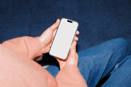 Phone mockup with white screen in hand on lap