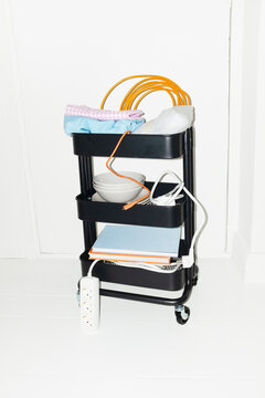 Modern cart filled with office items: wires, technology, books 
