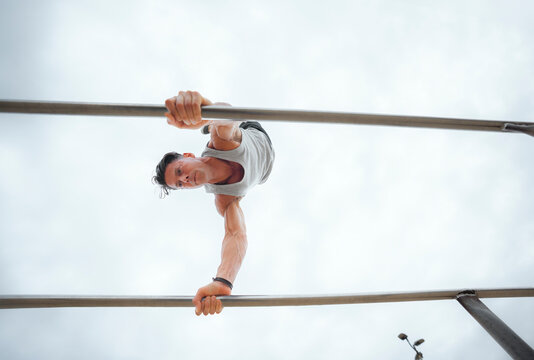 Man performs workout on bars
