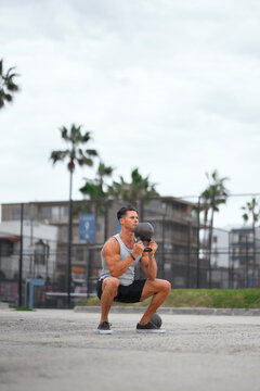 Man squatting with kettlebell
