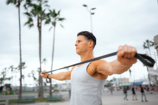 Man works out with band outside
