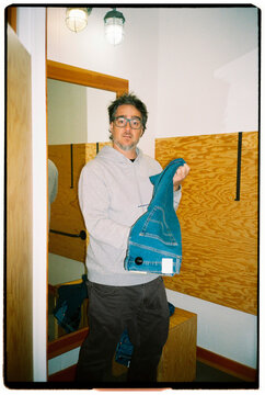 Man holding jeans in a fitting room 