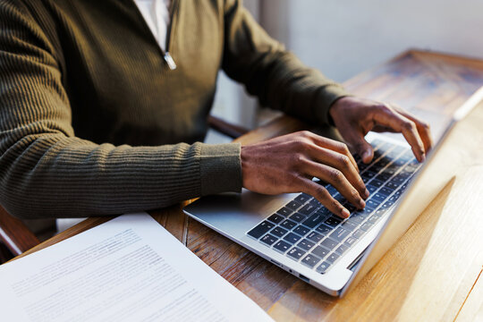Man typing on laptop keyboard working remotely at office