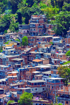 Conjunto habitacional urbano denso em uma favela do Rio de Janeiro, Brasil, com pr&eacute;dios de tijolos vermelhos em uma encosta.