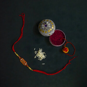 Traditional Indian Rakhi set with rice and decorative box.