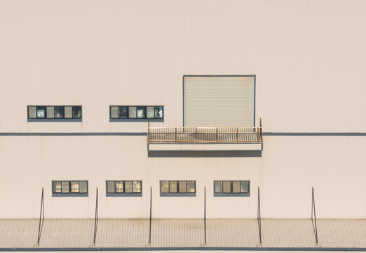 Minimalist Beige Warehouse Facade with Shutter Balcony