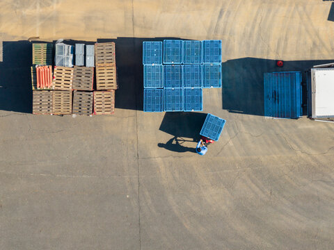 Aerial View of Worker with Blue Crates Loading Dock with Truck.