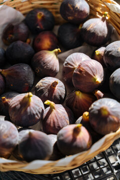 Fresh figs in a woven basket under sunlight