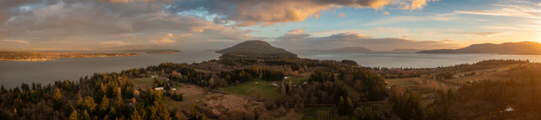 Aerial sunset panorama of the south end of Lummi Island located near Bellingham, WA in the Salish Sea. Drone shot of this rural treasure with farmland and coastal beach walks and beautiful forestland. © LoweStock