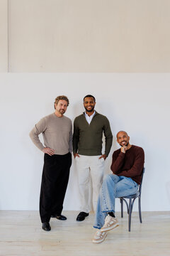 Smiling men enjoying friendship and teamwork posing at studio