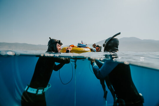 freedivers adjusting training equipment at surface