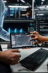 Close up of system administrators using tablet in server farm with hardware supporting data mining....