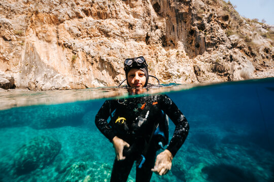 Young scuba diver preparing in calm Mediterranean bay