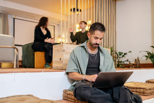 Millennial man working with laptop in coliving