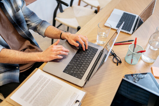 Person typing on laptop in a modern workspace