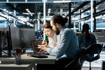 Team of software developers in data center integrating AI driven automation tools. Server farm IT professionals doing brainstorming, using artificial intelligence deep learning models