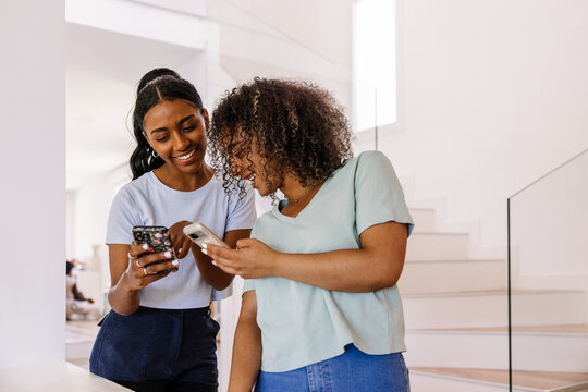 Two friends enjoying time together on their phones