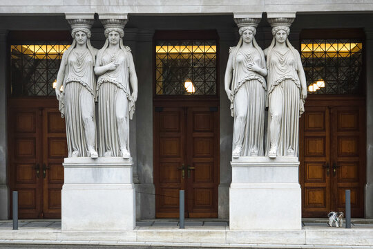 Classical female caryatid statues supporting a portal of a historic building
