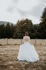 Mari&eacute;e de dos en robe blanche dans un paysage naturel - concept mariage romantique